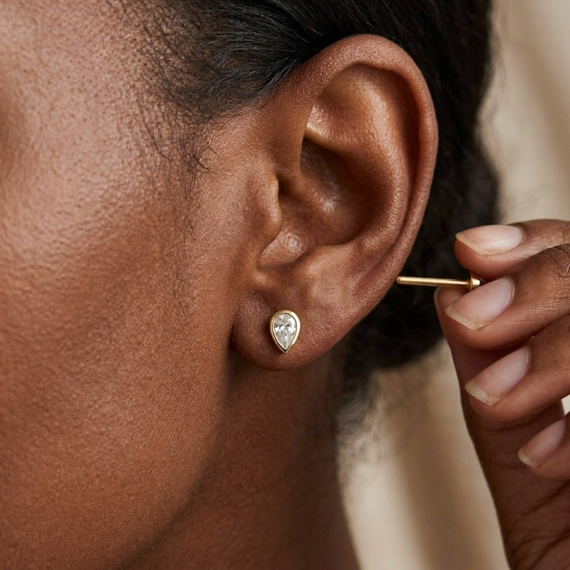 Worn: Pear Bezel-Set Stud Earrings · 0.05–0.2 ct — AI-rendered styling image