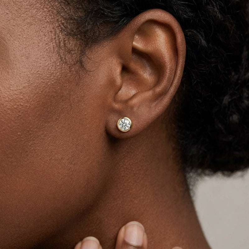 Worn: Round Bezel-Set Stud Earrings · 0.17–0.5 ct — AI-rendered styling image