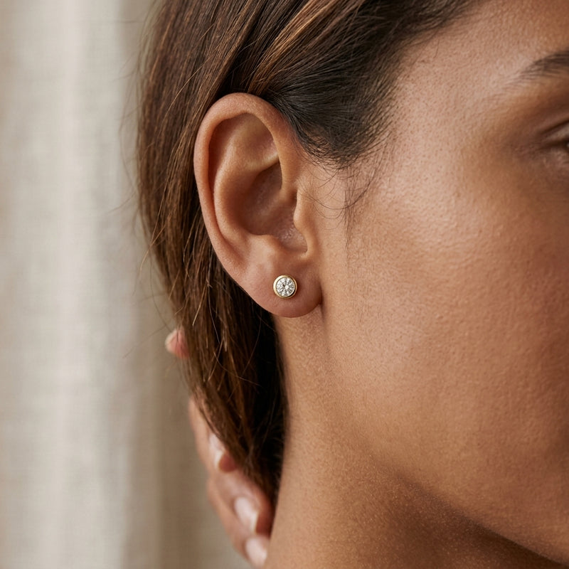 Worn: Round Micro Bezel-Set Stud Earrings · 0.01–1 ct — AI-rendered styling image